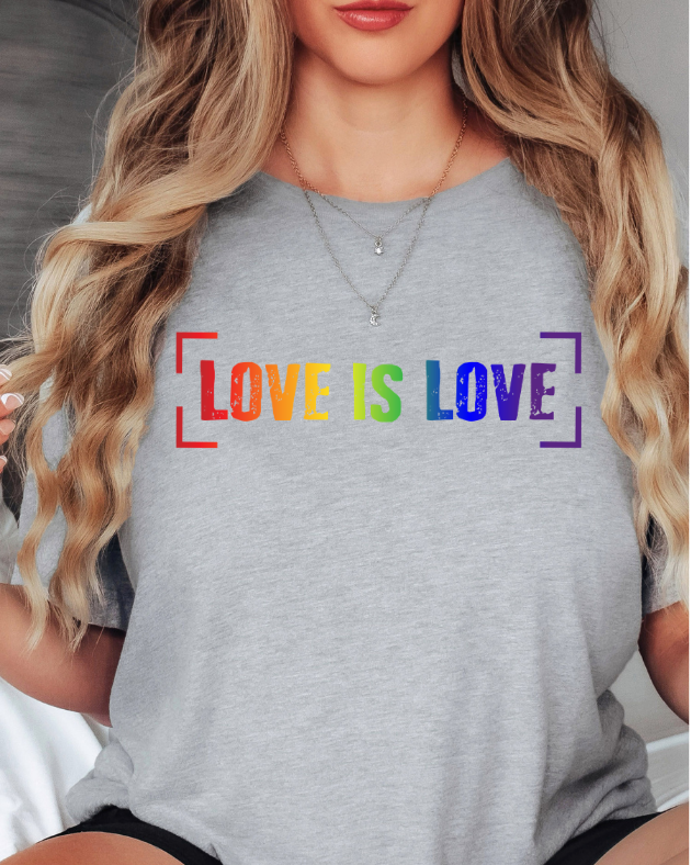 Person wearing a gray t-shirt with 'LOVE IS LOVE' in rainbow pride colors.