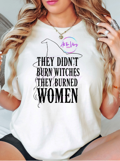 Model wearing white shirt that says They Didn’t Burn Witches, They Burned Women feminist graphic T-shirt with witch silhouette design.