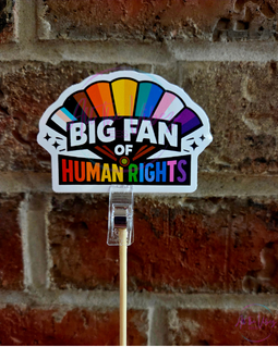 Big Fan of Human Rights vinyl sticker featuring a colorful fan design on a brick background. Progressive pride sticker for laptops, water bottles, tumblers, and cars.