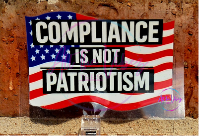 Compliance Is Not Patriotism 2x2 UV vinyl sticker featuring bold text over an American flag