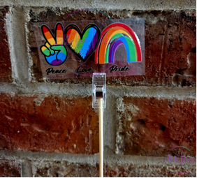 Rainbow peace hand and rainbow UV vinyl sticker displayed outdoors. Waterproof vinyl decal for laptops, water bottles, tumblers, notebooks, and vehicles.