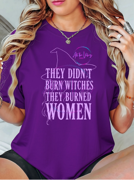 Model wearing a purple They Didn’t Burn Witches, They Burned Women feminist graphic T-shirt with witch silhouette design.